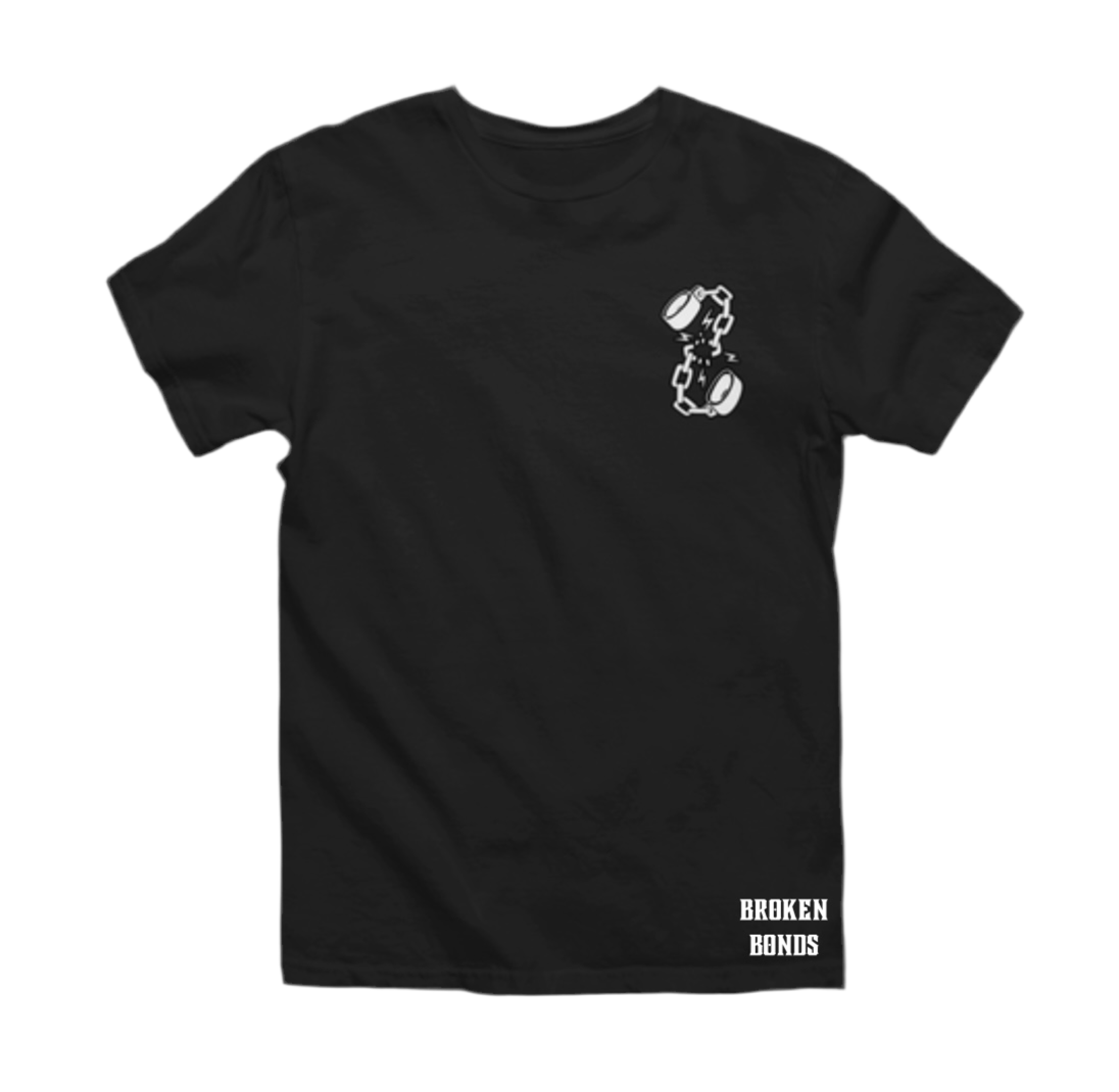 This image shows a black T-shirt with a minimalist design. The front of the shirt features a small graphic on the left chest area, depicting broken shackles with lightning bolts around the break, symbolizing breaking free. Additionally, the bottom right corner of the shirt has the text “BROKEN BONDS” in bold, white capital letters.