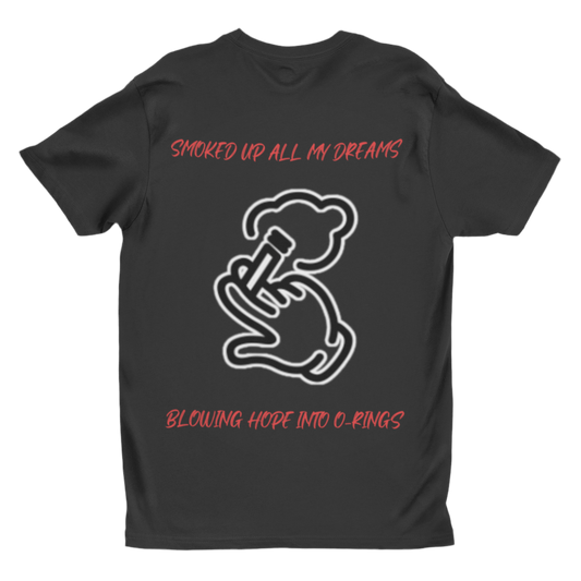 This black T-shirt in the image has a white outline graphic of a hand holding a smoking object, exhaling a cloud of smoke. The text on the shirt is red and reads: “SMOKED UP ALL MY DREAMS” (at the top)
“BLOWING HOPE INTO O-RINGS” (at the bottom) 